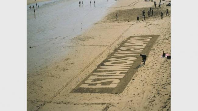 Daniel G. Andújar, <em>Estamos vigilando</em>, 1994. Intervención en espacio público, imagen de la playa de La Concha, San Sebastián. Cortesía del artista