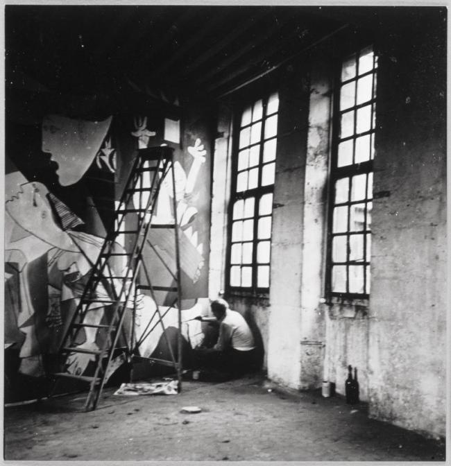 Picasso fotografiado por Dora Maar sentado en el suelo de su estudio trabajando en Guernica