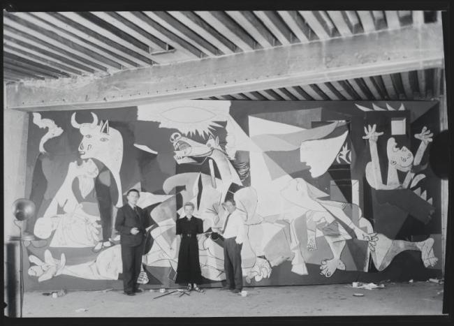 Pablo Picasso, André Breton y Jacqueline Lamba fotografiados por Dora Maar en el taller de la Rue des Grands-Augustins ante Guernica durante el proceso de creación
