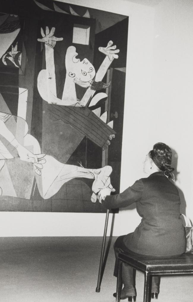 A visitor contemplating Guernica during the exhibition Pablo Picasso: A Retrospective