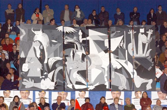 Simpatizantes socialistas izan una pancarta de Guernica durante el mítin del candidato José Luis Rodríguez Zapatero
