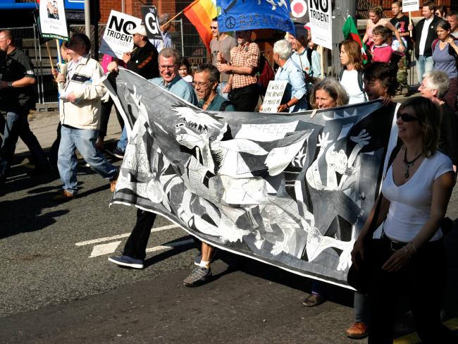 Manifestantes contra la guerra de Irak sosteniendo una pancarta con una réplica de Guernica