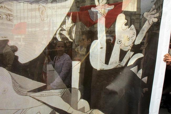 Manifestantes vistos a través de una pancarta con la imagen de Guernica en una protesta contra la invasión de Irak