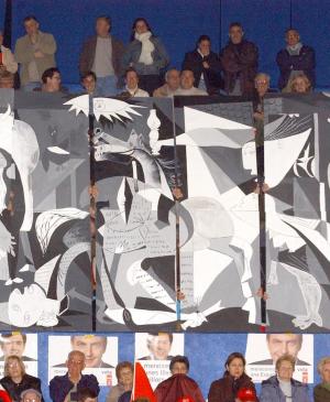 Simpatizantes socialistas izan una pancarta de Guernica durante el mítin del candidato José Luis Rodríguez Zapatero
