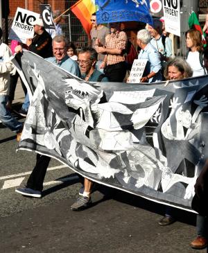 Manifestantes contra la guerra de Irak sosteniendo una pancarta con una réplica de Guernica