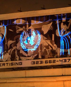 Réplica de Guernica con el logotipo de la ONU proyectado en la intersección de Hollywood and Sunset Boulevard